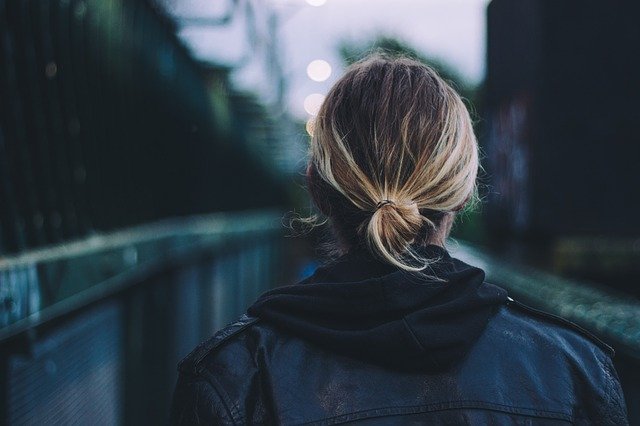 woman facing a long bridge