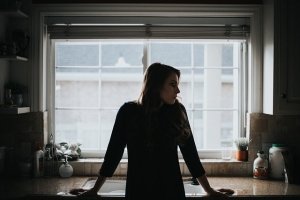 woman leaning on kitchen counter alone